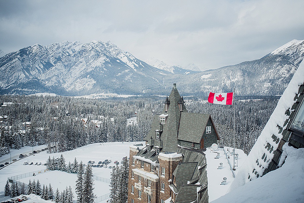 canadian-flag-waving-atop-banff-springs-hotel-rockies-in-background