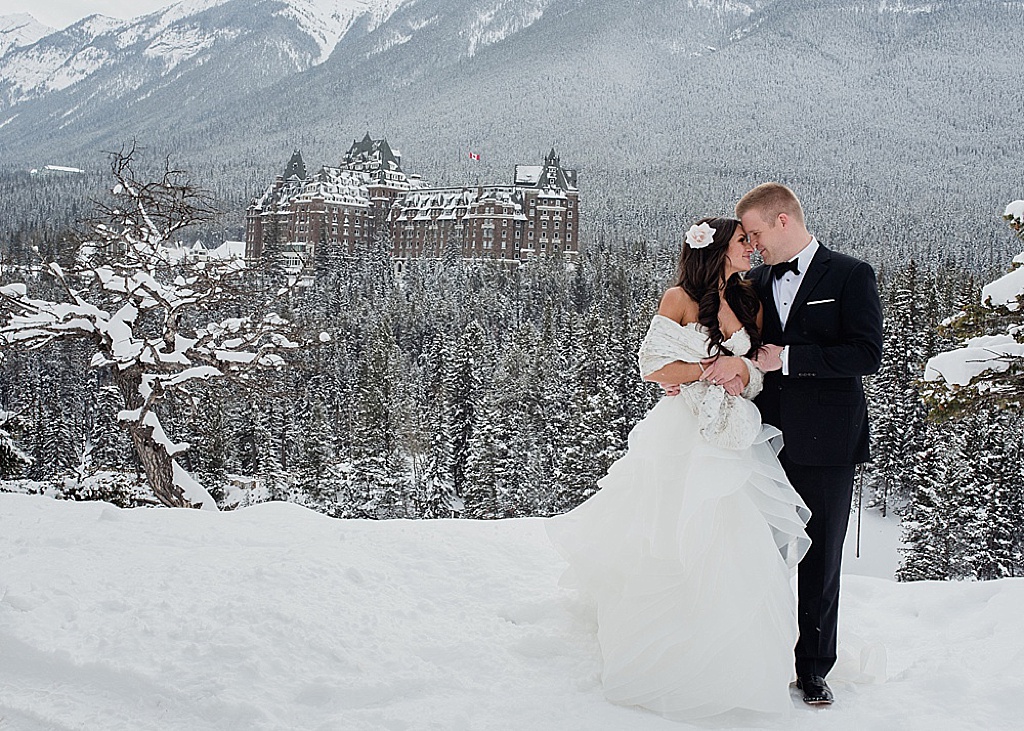 couple-standing-in-front-of-banff-springs-hotel-winter