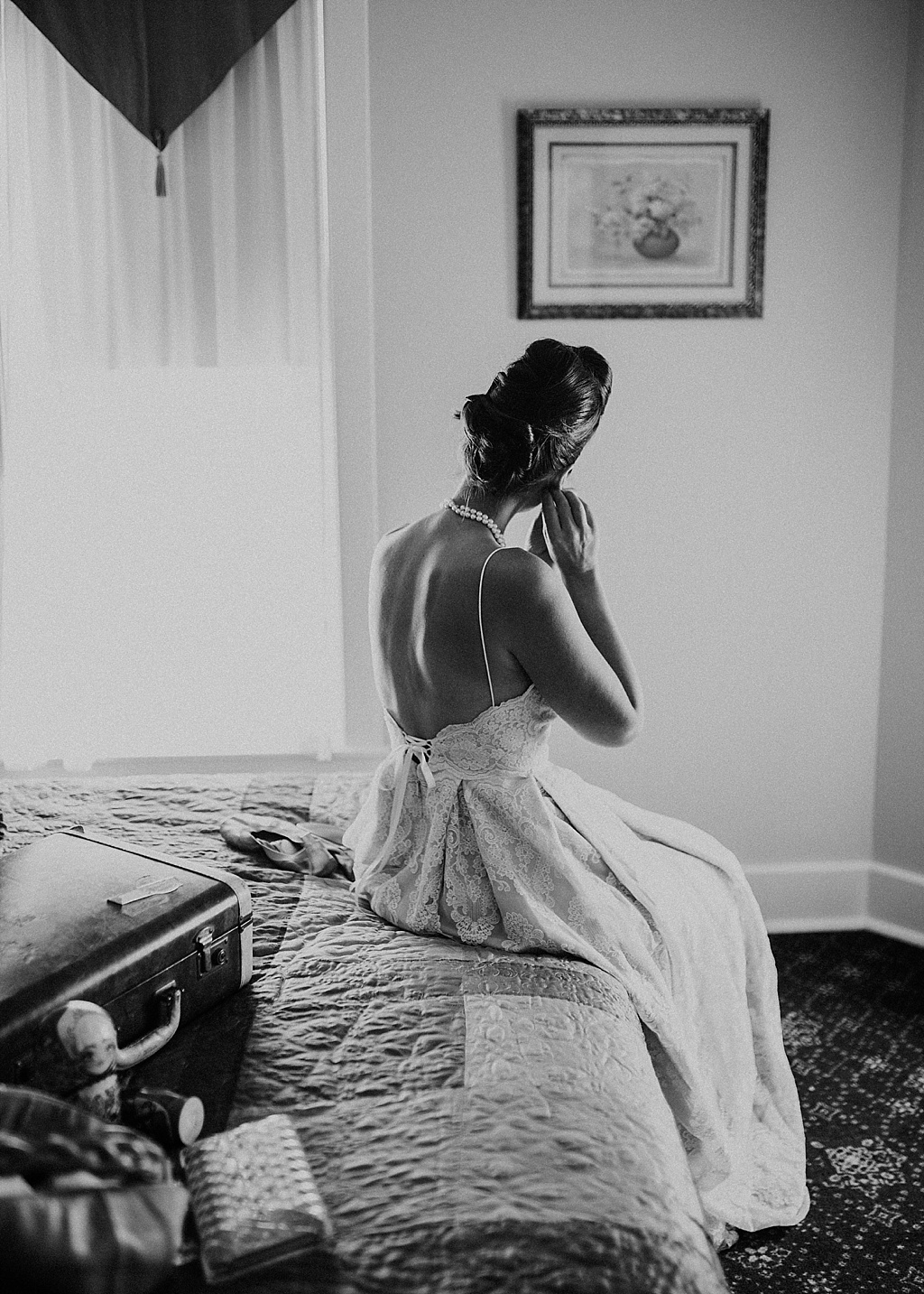 bride-sitting-down-putting-on-earrings-black-and-white
