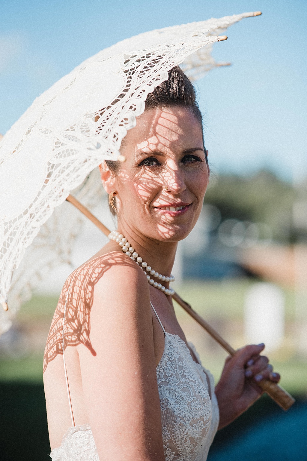 beautiful-bride-holding-lace-umbrella-with-sun-shining-through