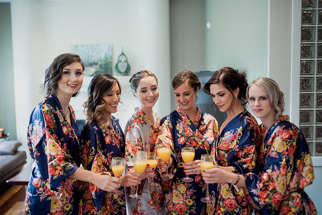 bride-bridesmaids-toasting-orange-juice-in-flower-robes